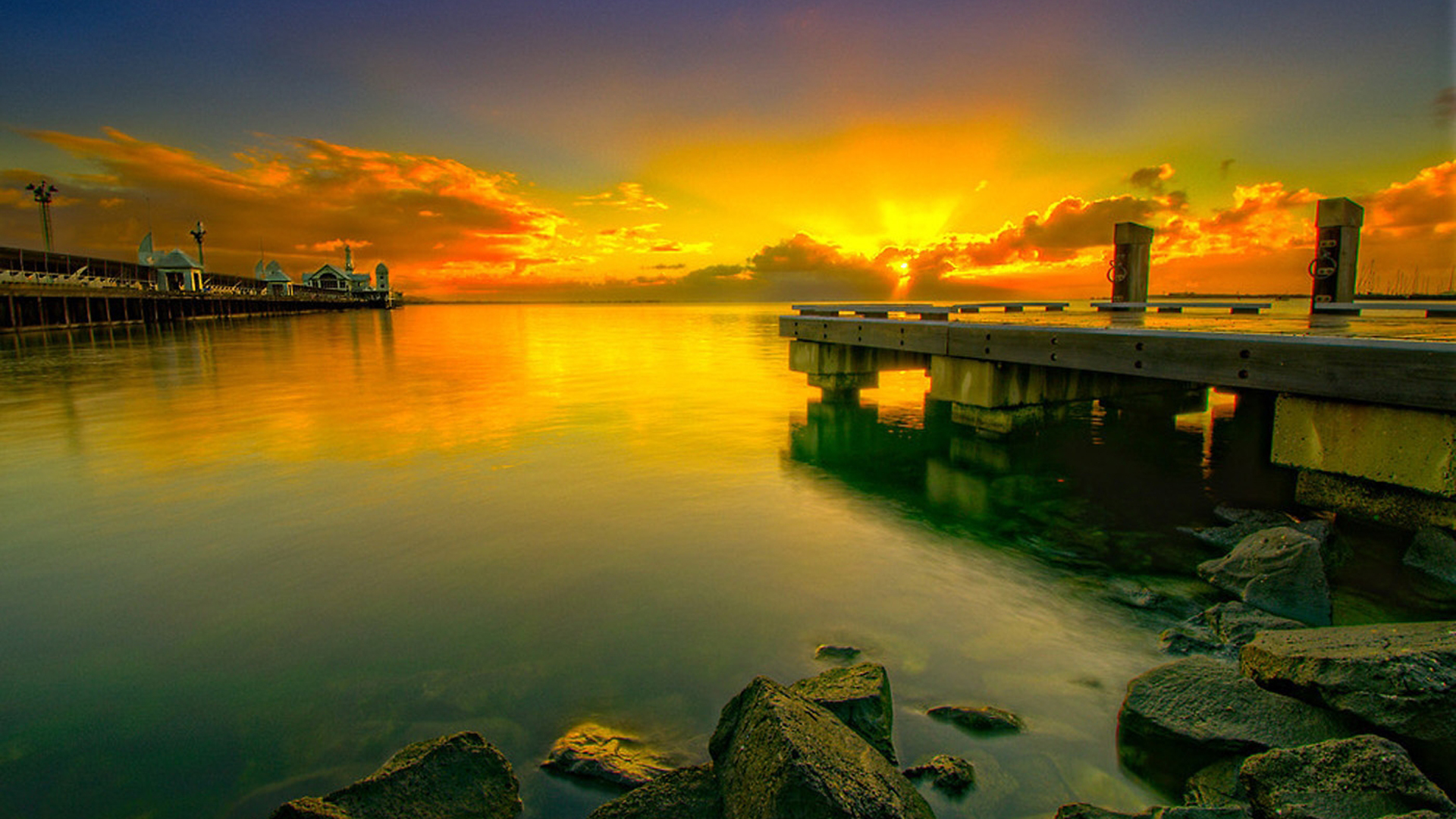 Pier Stones On Body Of Water Under Yellow Black Clouds Sky During Sunset 2K Nature