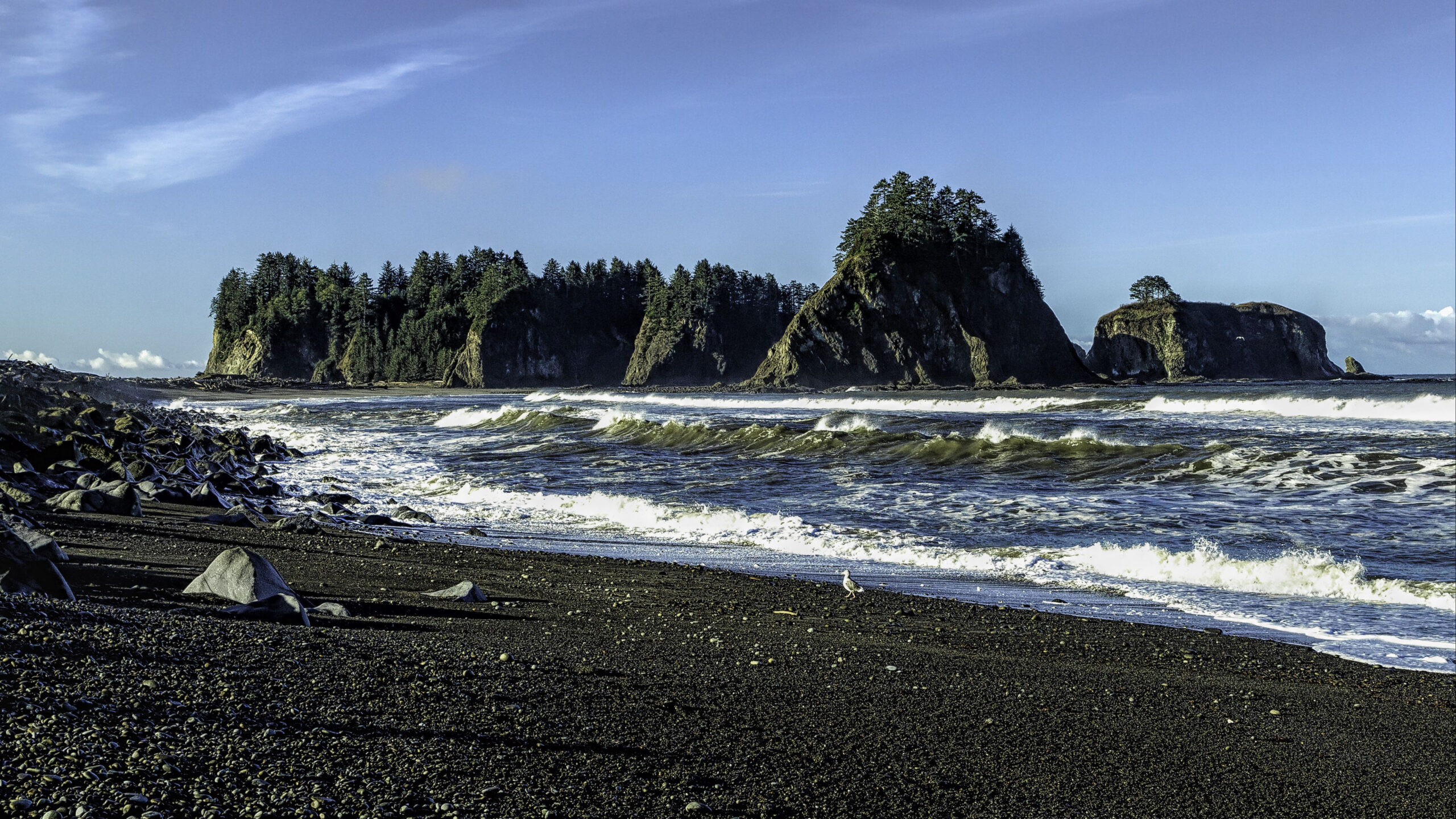 Ocean Waves Black Beach Sand Shells And Landscape View Of Rock Mountains With Green Trees Under Blue Sky K 2K Nature