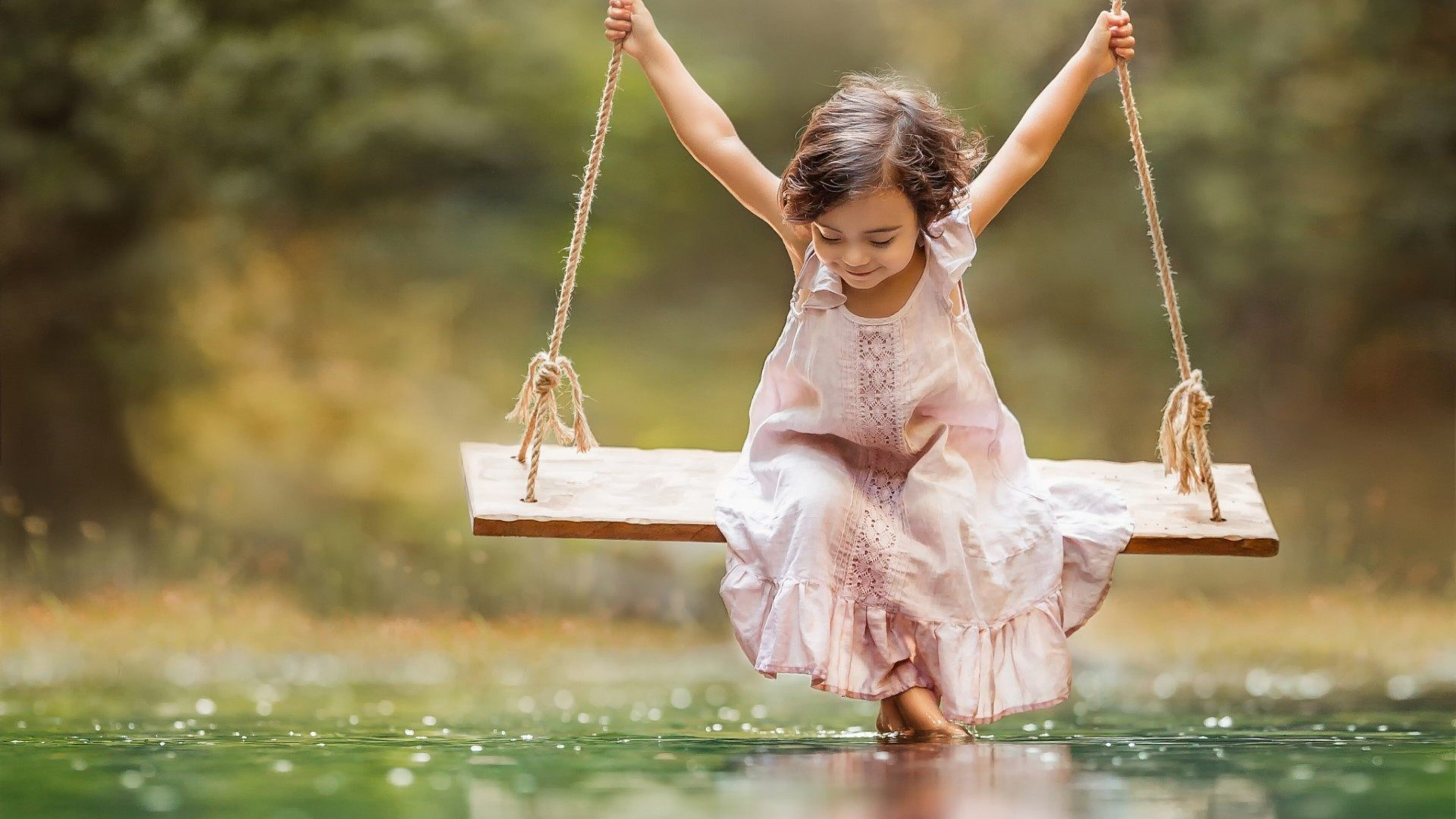 Cute Little Girl Is Wearing Light Peach Dress Riding On Swing Over River During Daytime K 2K Cute