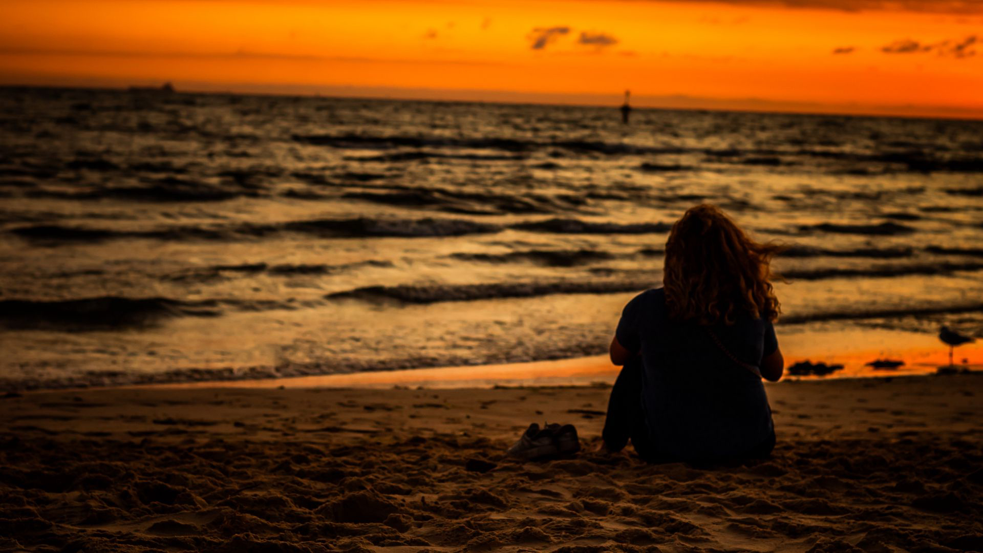 Girl Is Sitting On Beach Sand Watching Ocean Waves During Sunset 2K Beach