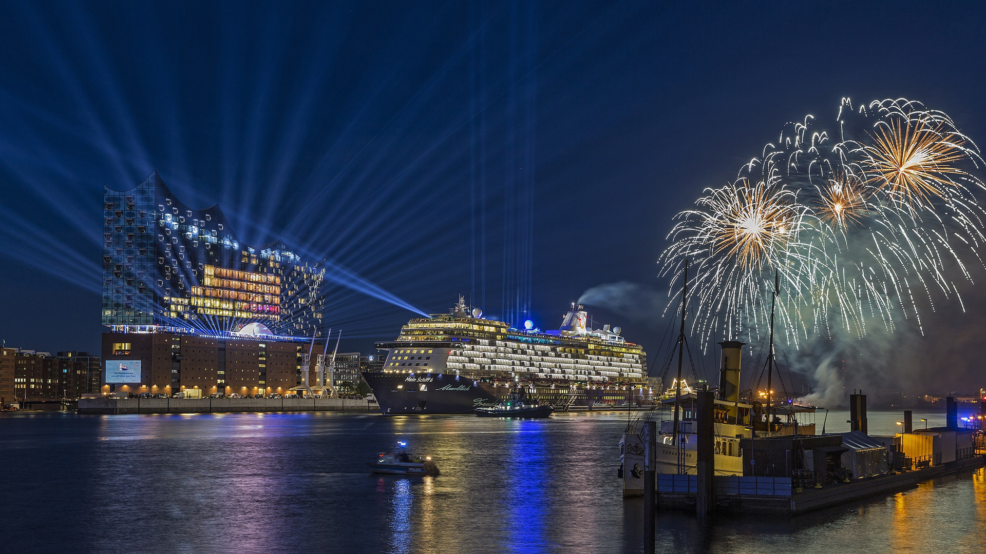 Black Cruise Ship With Blue Light Focusing And Fireworks On Side During Nighttime 2K Cruise Ship