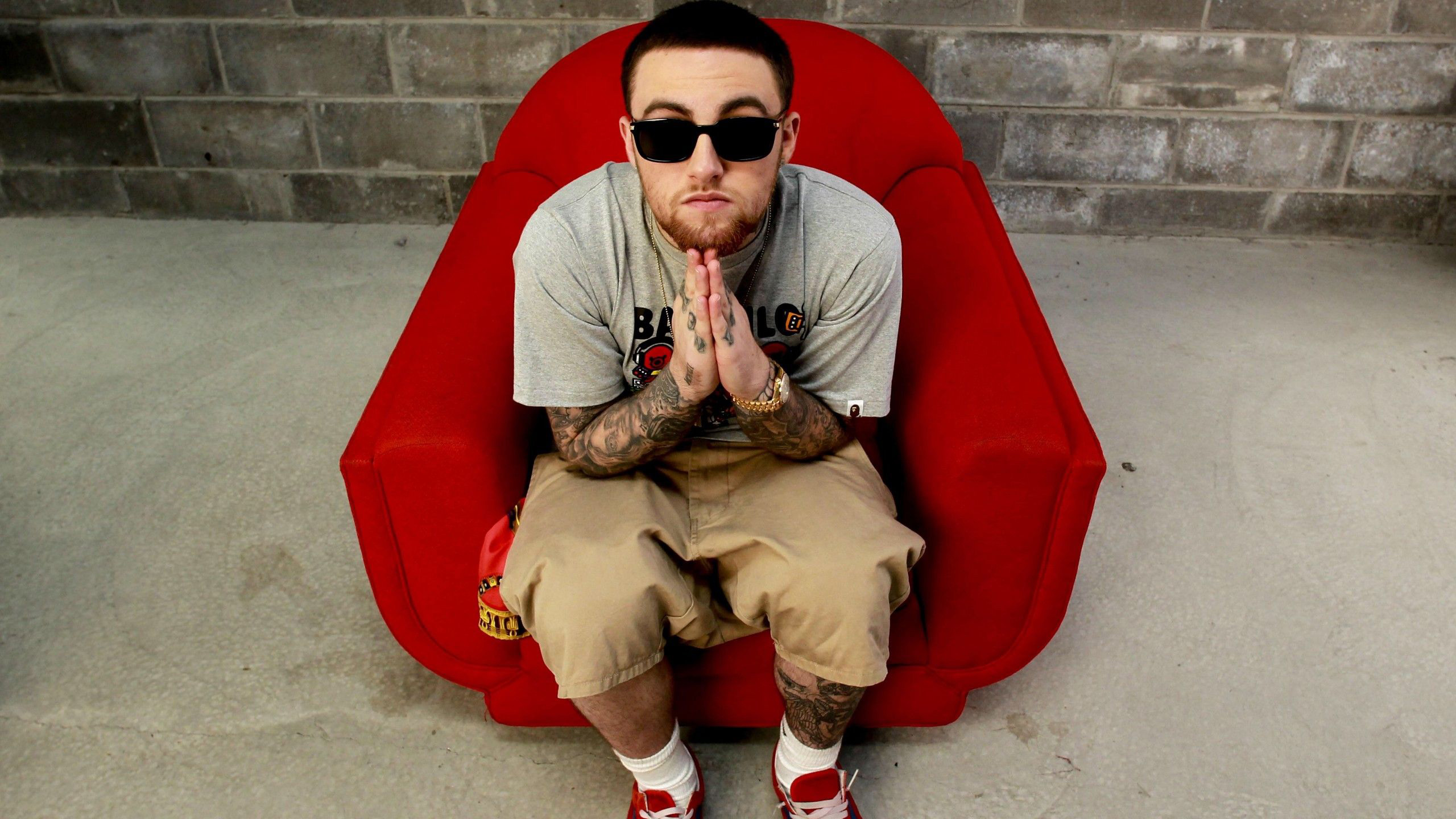 Mac Miller Is Sitting On a Red Couch Wearing Cap And Goggles 2K Celebrities