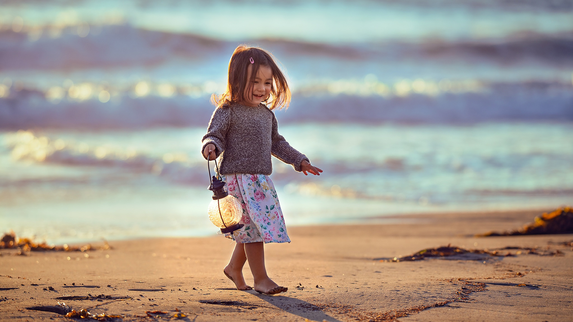 Cute Little Girl With Lantern Is Walking On Beach Sand Wearing White Flowers Printed Skirt And Black 4K 2K Cute