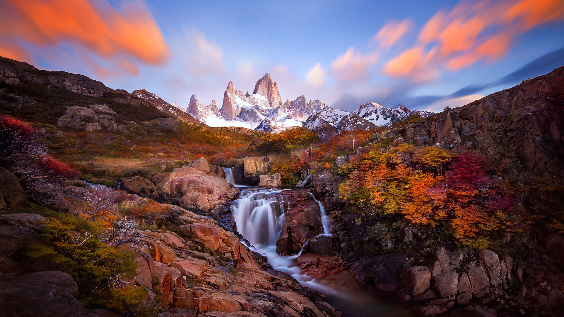 Waterfall Stream From Rocks Colorful Autumn Trees Snow Capped Mountains Under White Clouds Blue Sky 2K Nature