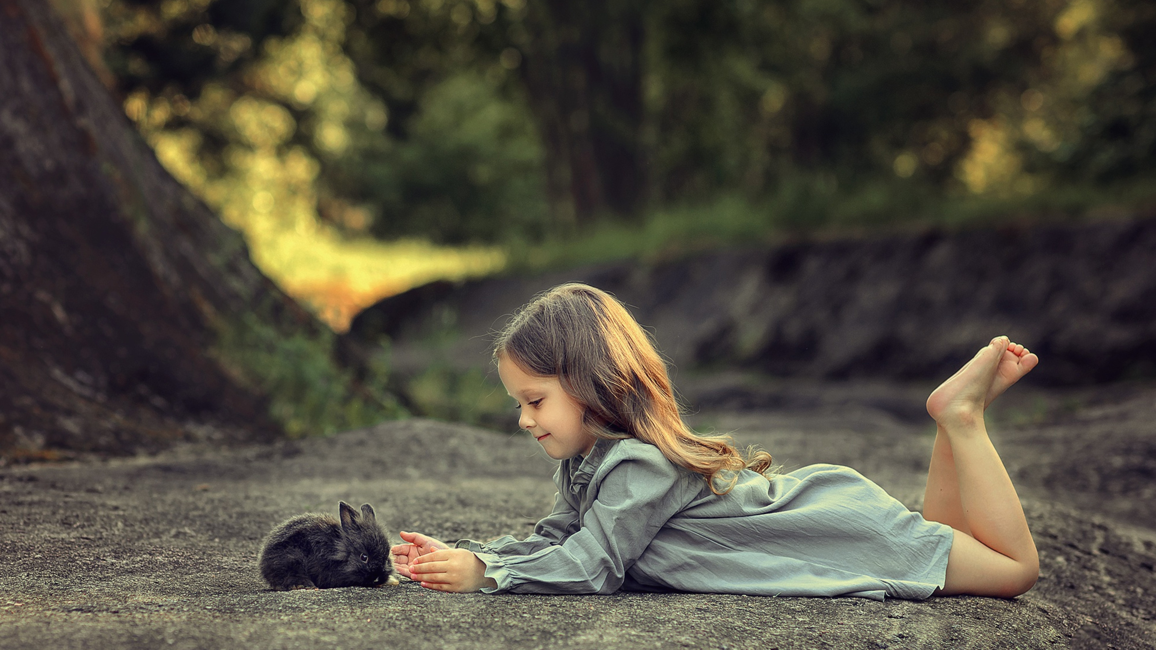 Little Girl Is Lying Down On A Road And Playing With Rabbit K 2K Cute