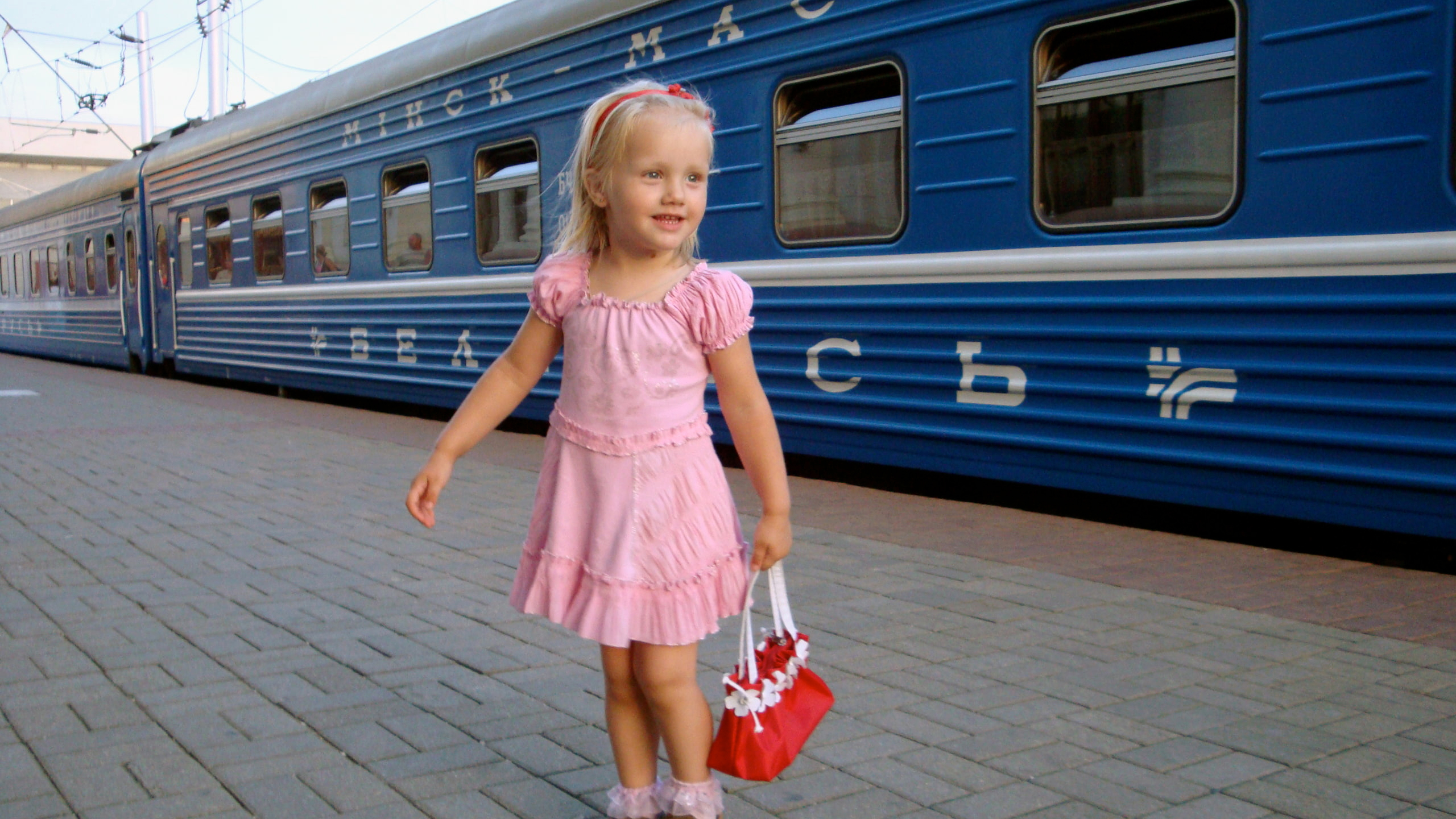 Cute Little Girl Is Wearing Pink Dress Standing In Blue Train Wallpaper 2K Cute
