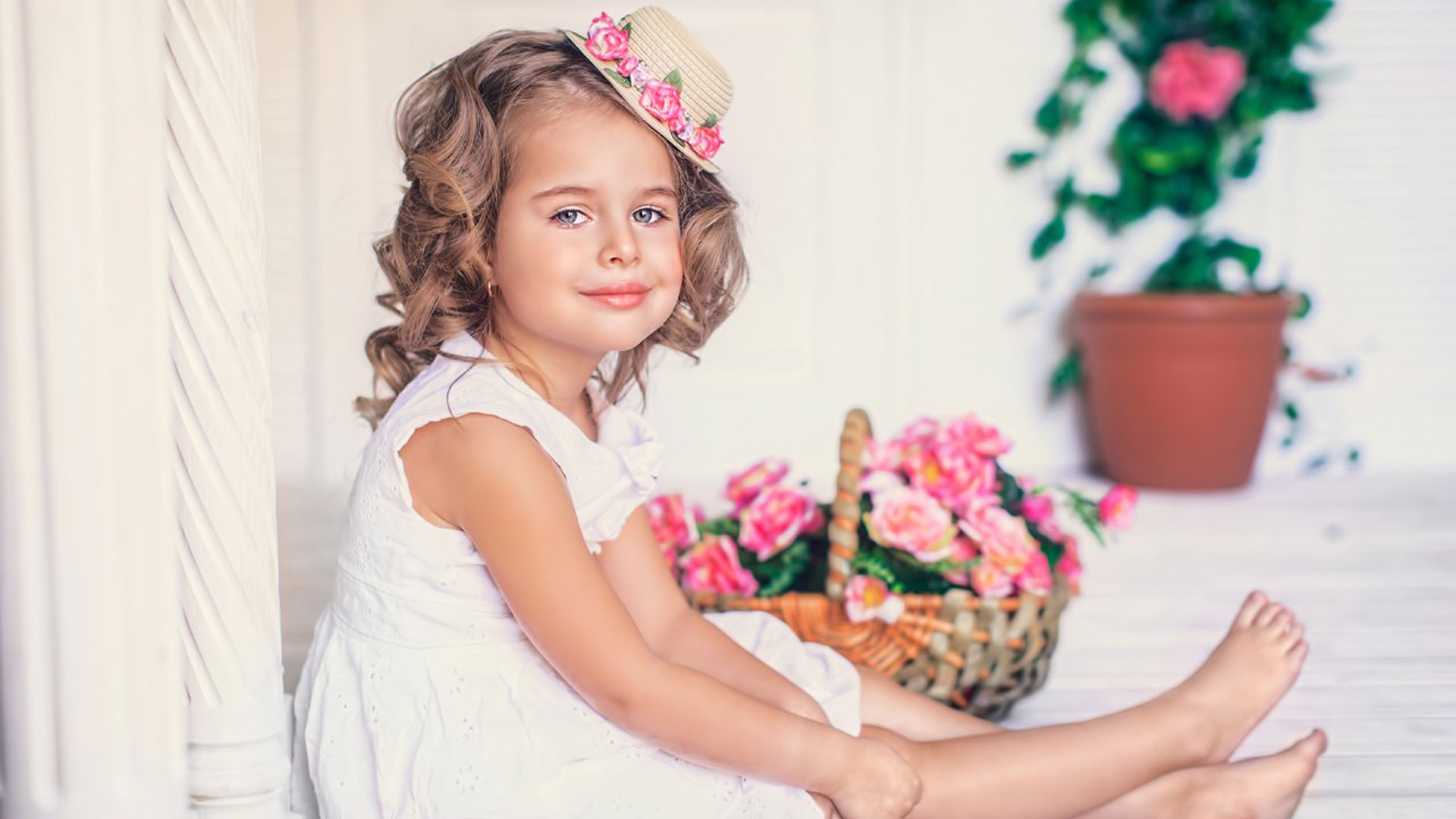 Smiley Cute Little Girl Is Wearing White Dress And Hat Shaped Hair Clip Sitting In White Wallpaper 2K Cute