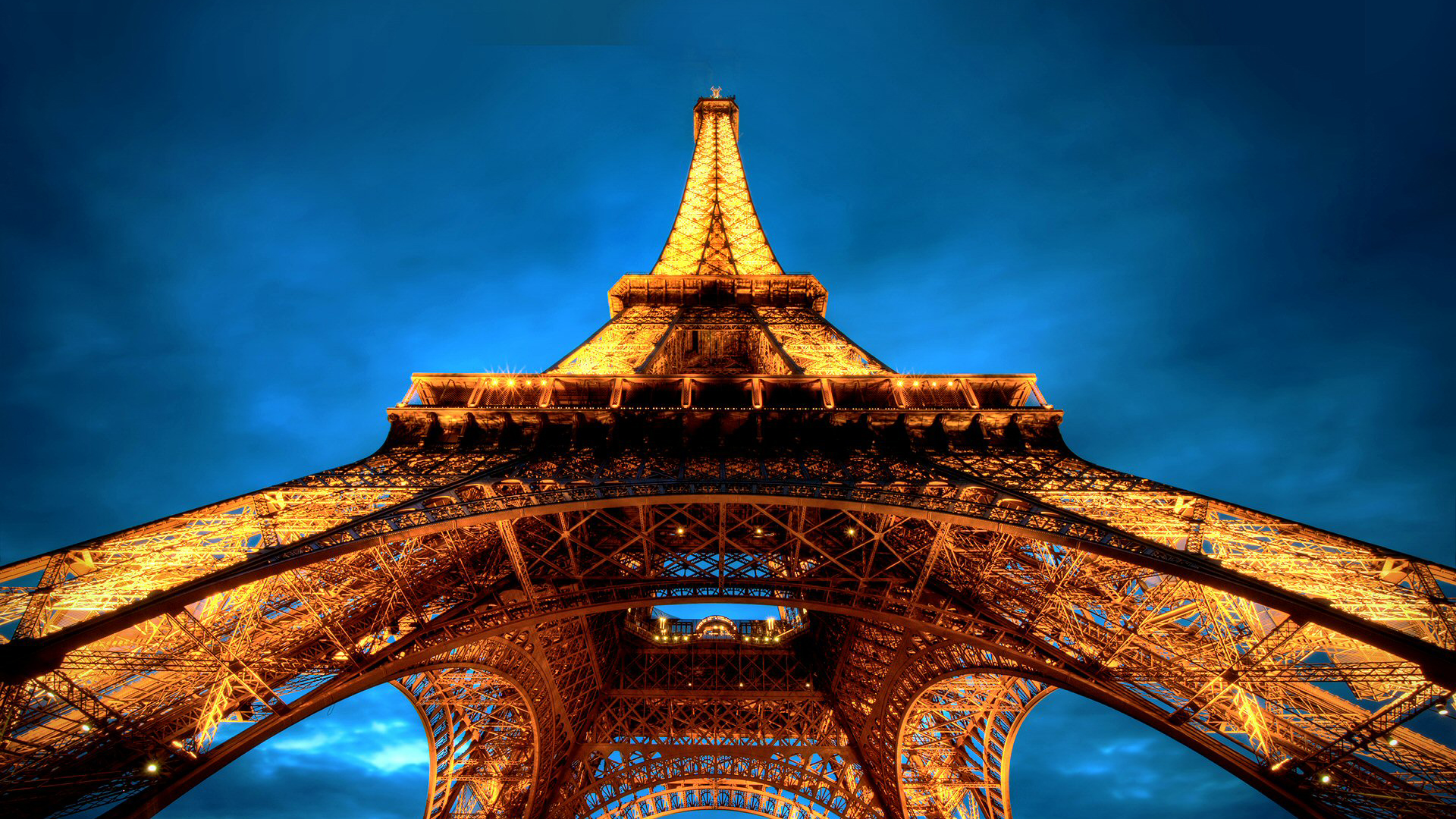 Upward View Of Yellow Lighting Paris Eiffel Tower With Blue Sky Wallpaper 2K Travel