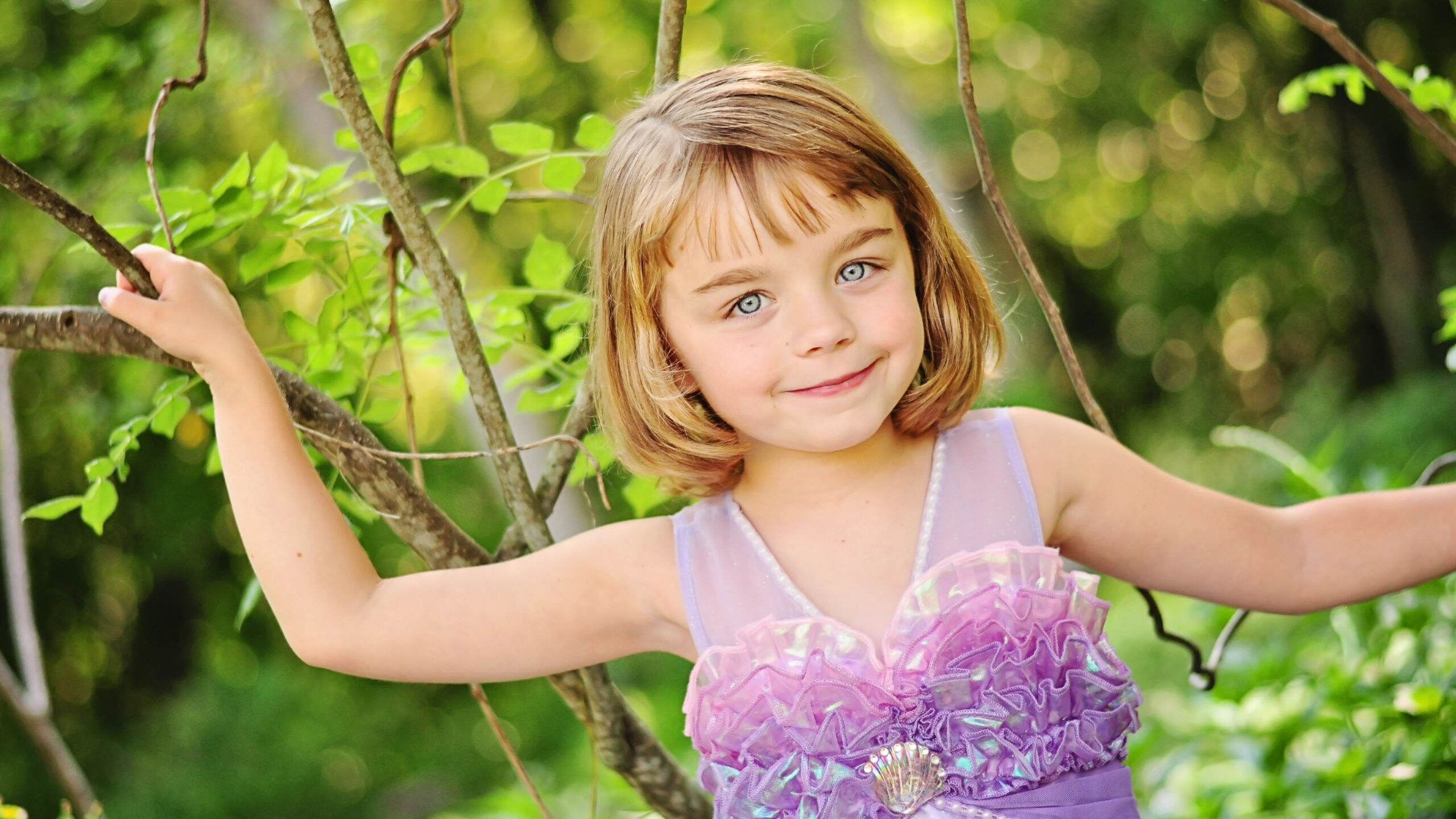Cute Little Girl Is Standing In Green Blur Bokeh Wallpaper Wearing Light Purple Dress K 2K Cute