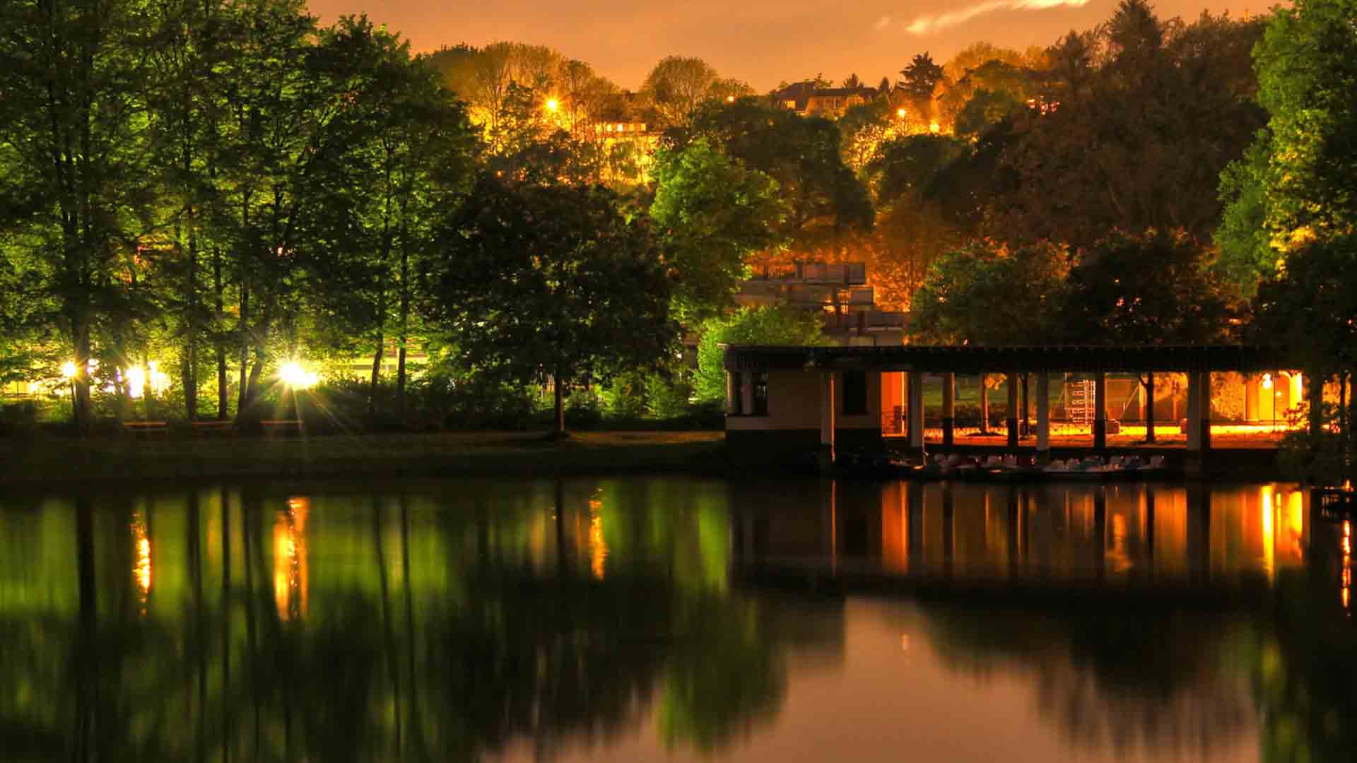 Beautiful Resort With Lights Surrounded By Trees With Reflection On Body Of Water 2K Beautiful